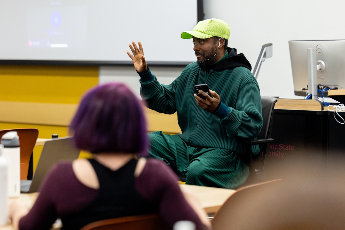 will.i.am gestures as he teaches in a classroom
